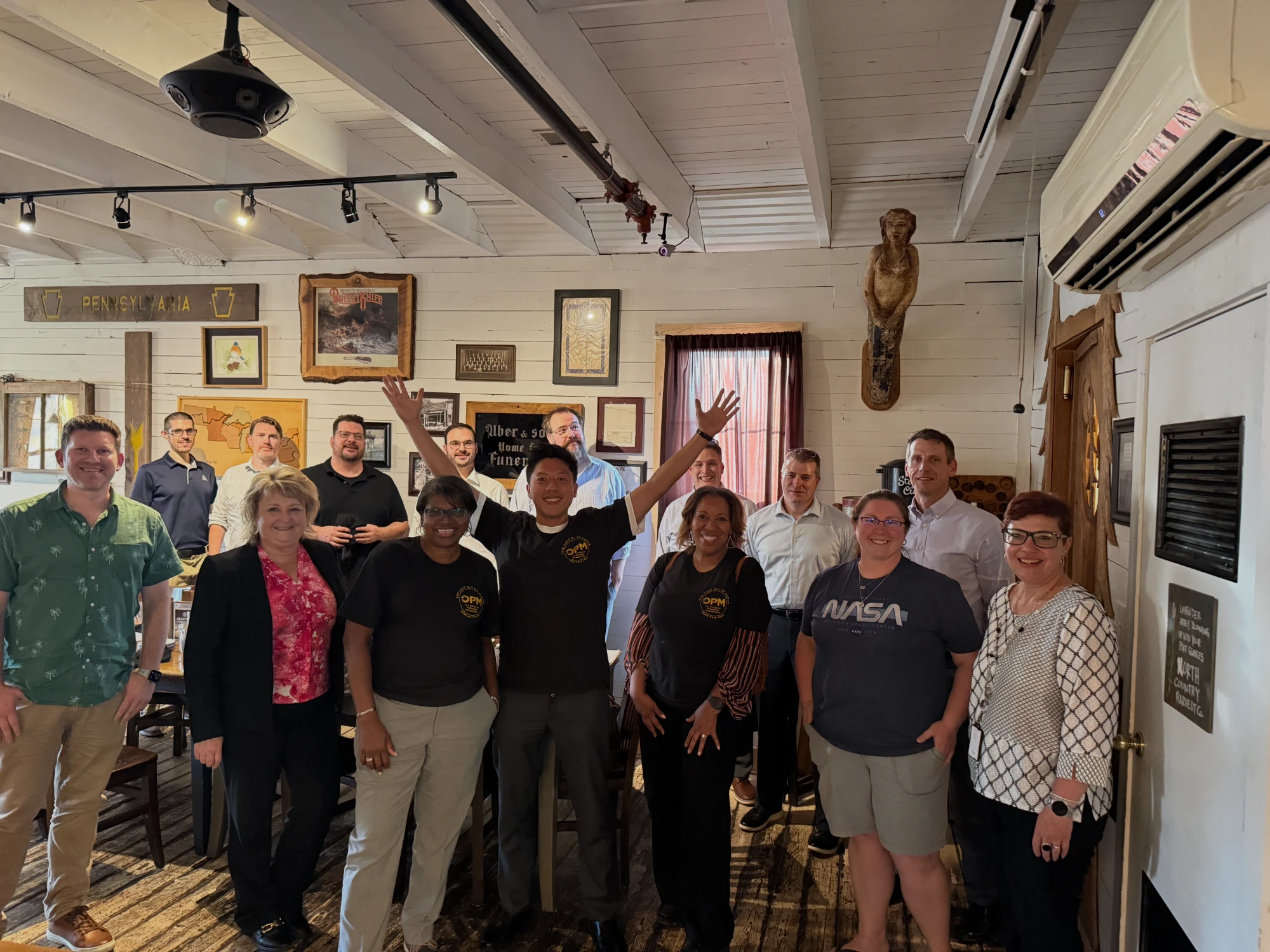 The retirement modernization team and agency staff celebrating together, some in “Last Day of Paper” shirts